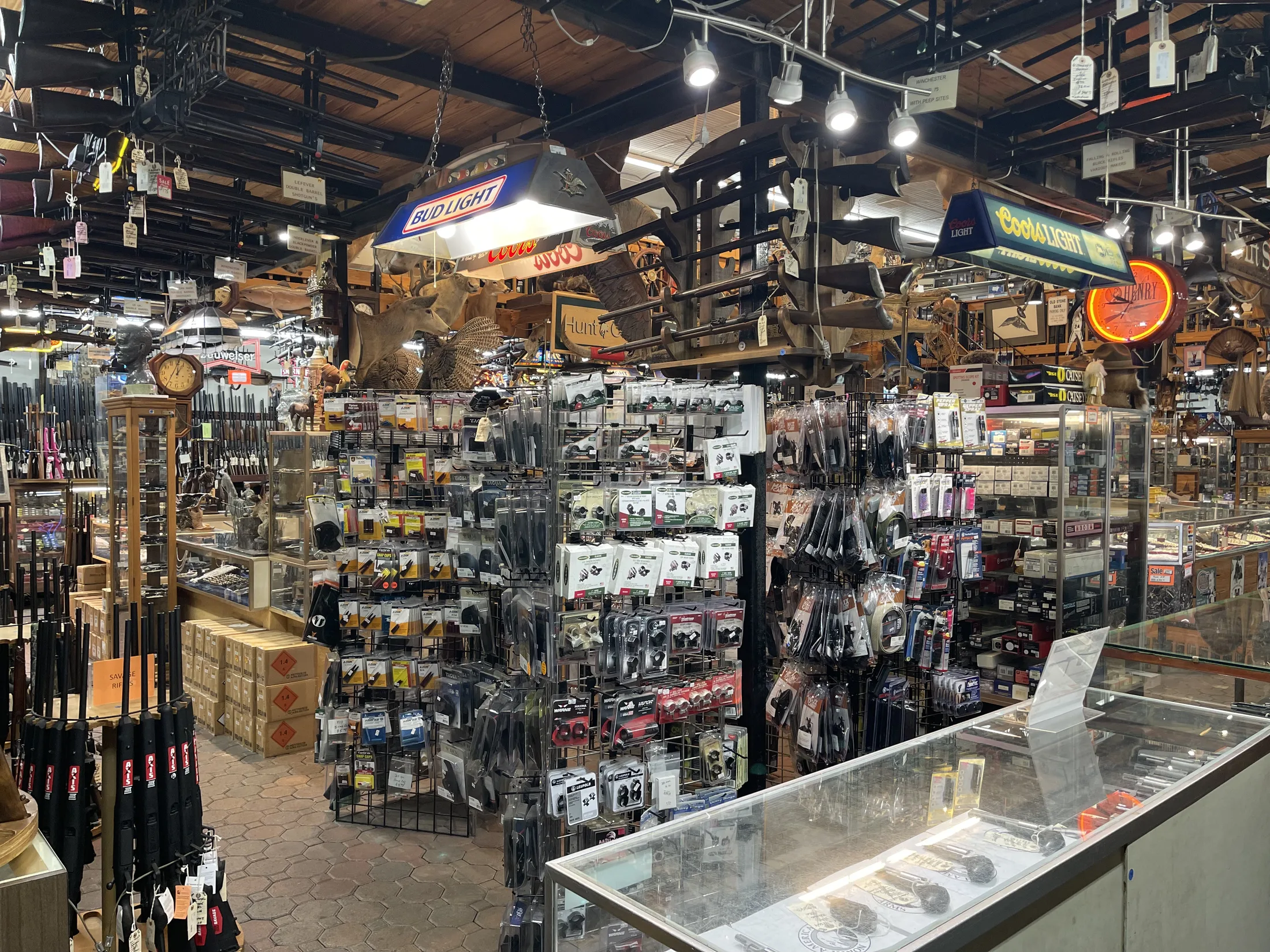 Wall of packaged accessories and showcases inside AAA Gun & Pawn